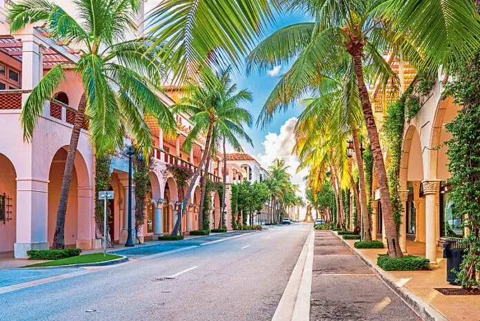 Worth Avenue in Palm Beach, Florida, lined with palm trees and Mediterranean-style storefronts