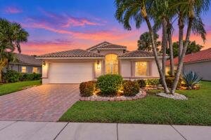 Single-family home for sale at 7625 Caprio Drive, Boynton Beach, FL, photographed at sunset with palm trees